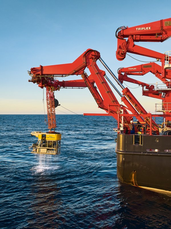 Kräne auf einem Forschungsschiff lassen einen Unterwasser-Roboter ins Wasser