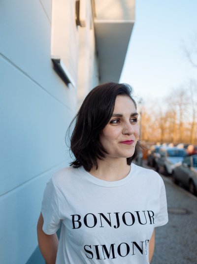 <p>Buch-Autorin Julia Korbik mit einem Shirt, auf dem „Bonjour Simone“ steht</p>
