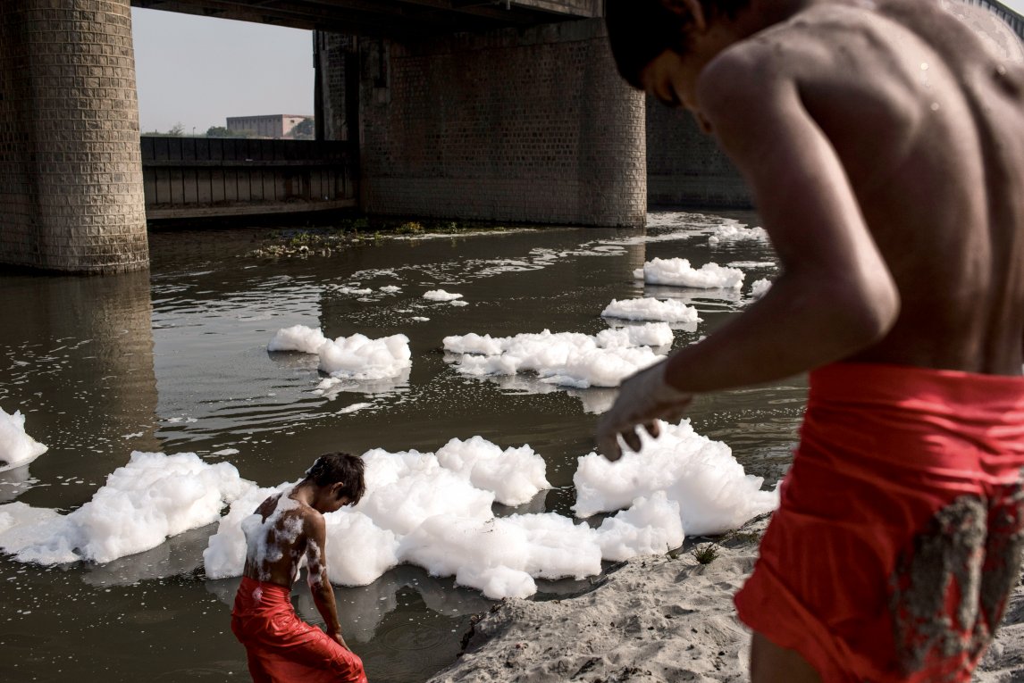 TRÜGERISCHES WEISS
Kinder halten den giftigen Schaum im indischen Fluss Yamuna für Seife
