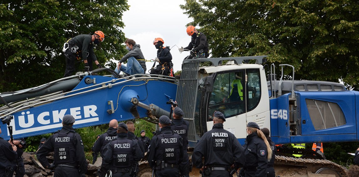 Eine Hundertschaft der Polizei rückte an, um die Landstraße im Kreis Heinsberg zu räumen – ein Aktivist war auf einen der Bagger geklettert
